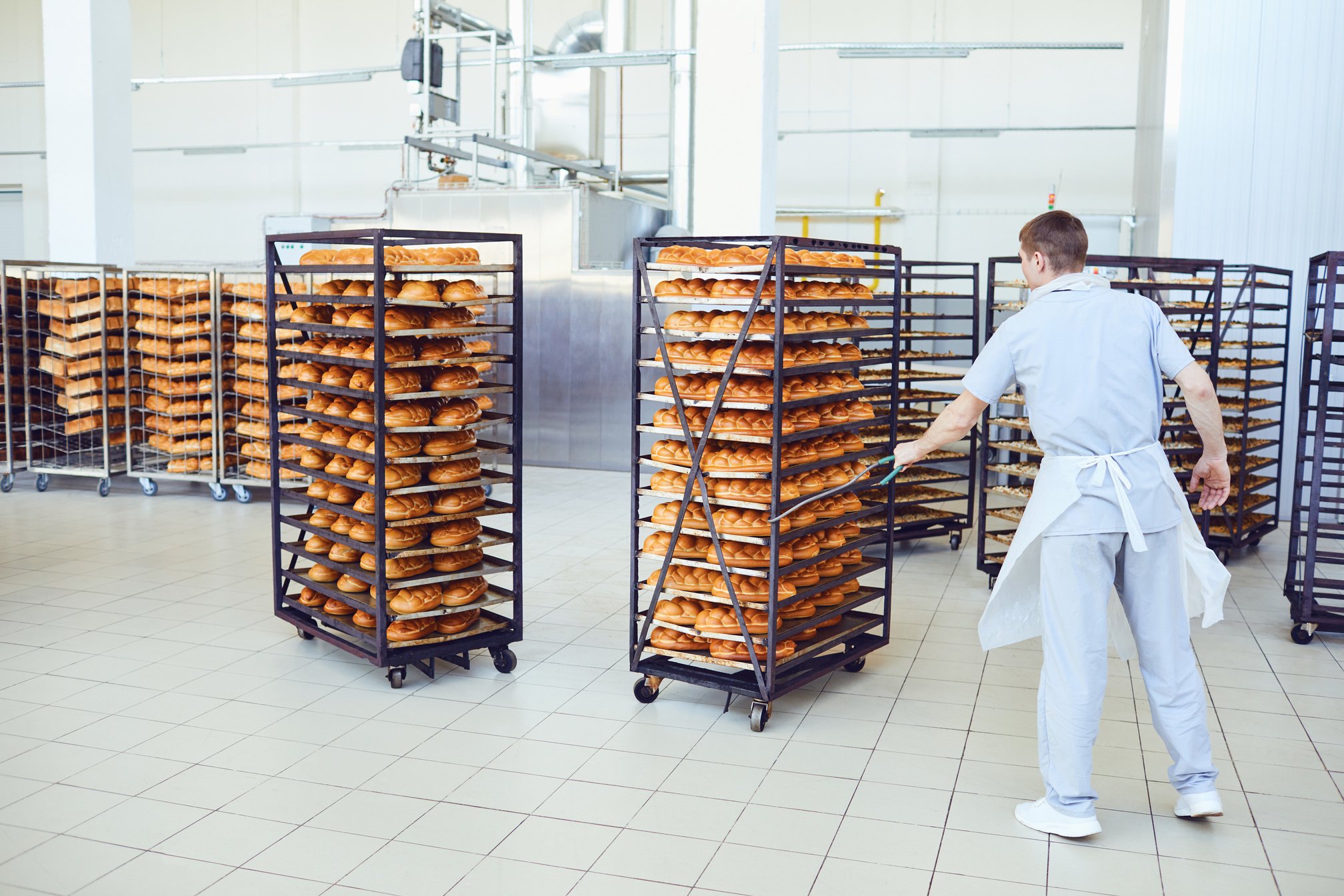 Bakery Worker Pulling Shelves with Bread